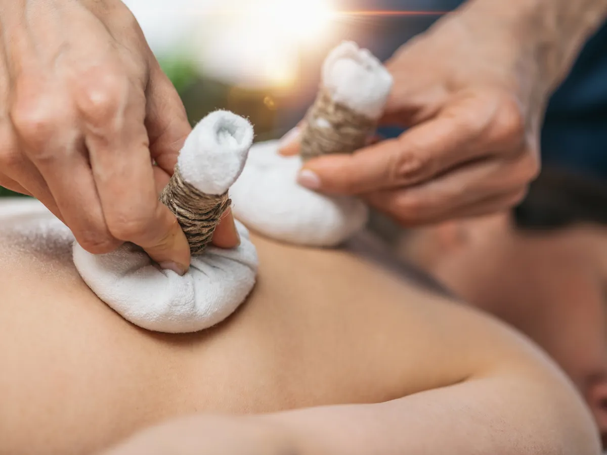 Herbal Potli bolus massage on the back during the Ayurvedic Pain Management Haridwar programme