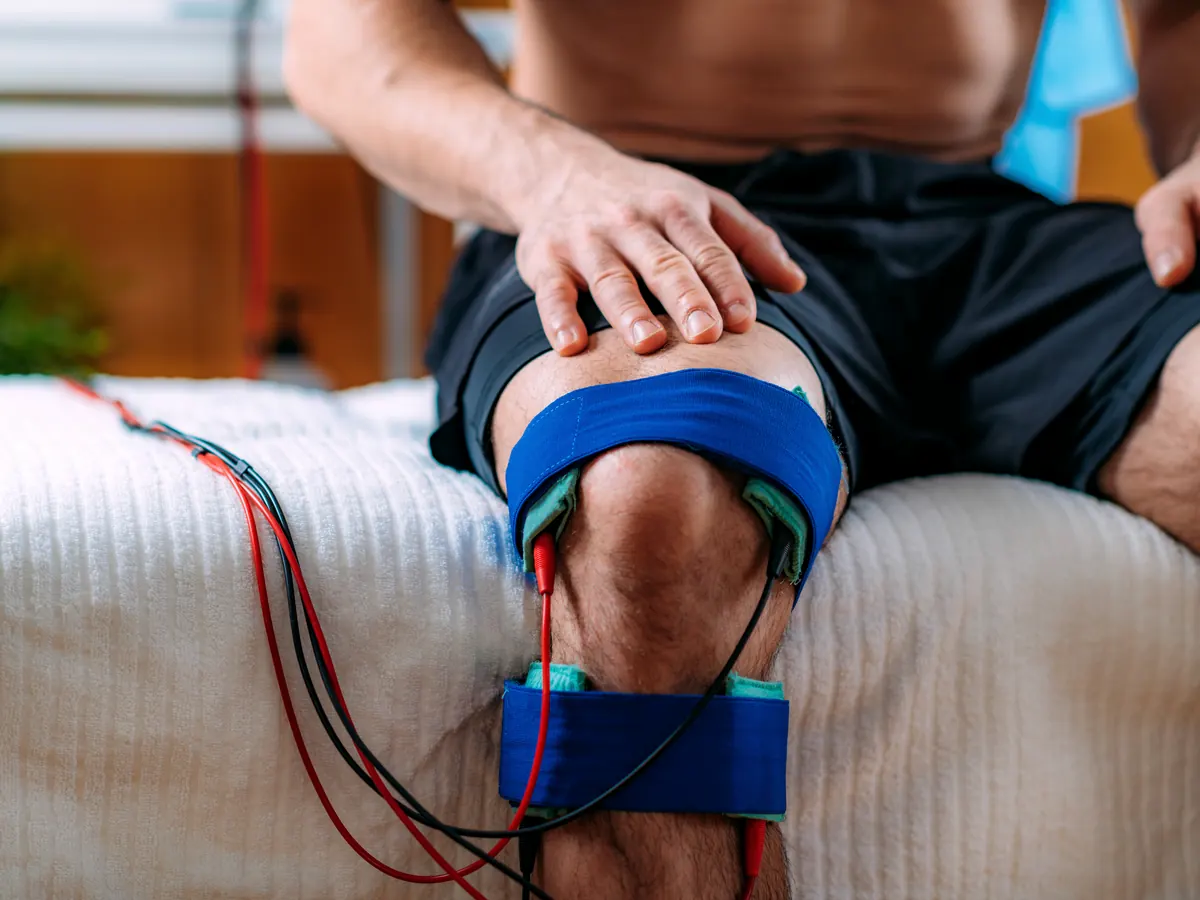 Knee interferential therapy electrode pads during physiotherapy in Haridwar at Divine Holistic Health Retreat